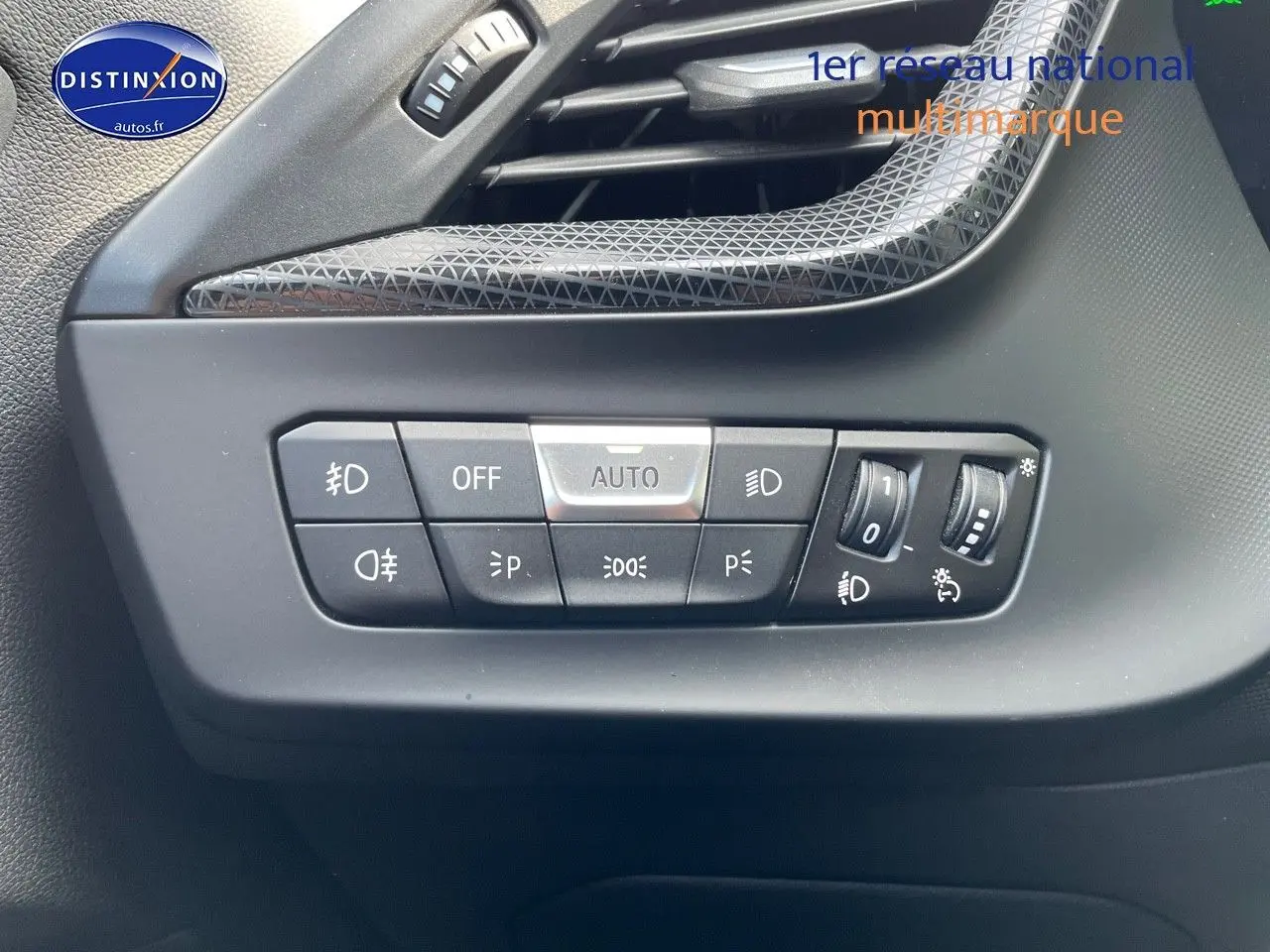 Gros plan sur les commandes d'éclairage à gauche du tableau de bord d'une BMW Série 1 gris minéral métal.