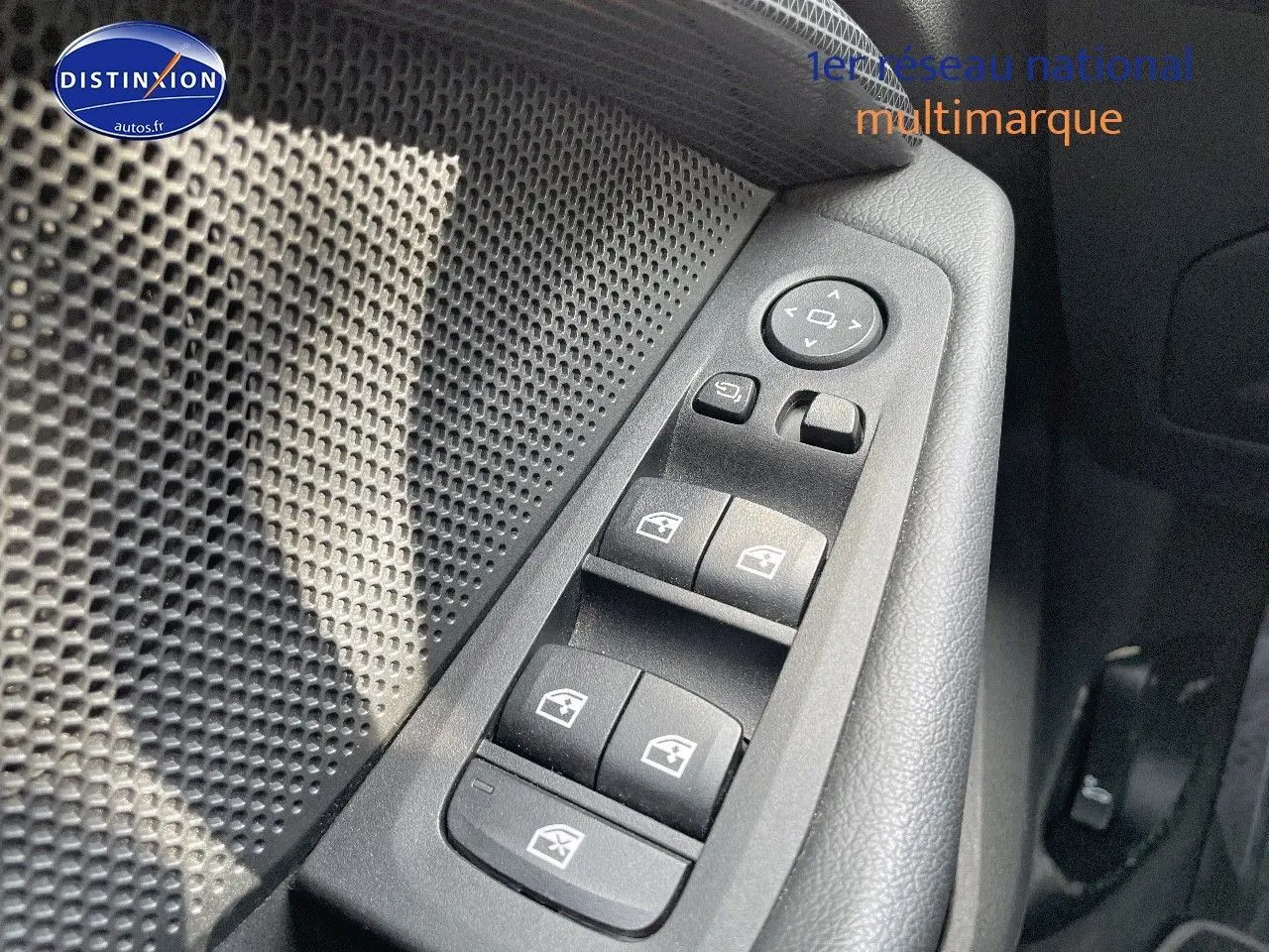 Gros plan sur les commandes des vitres électriques côté conducteur d'une BMW Série 1 gris minéral métal de 2021.