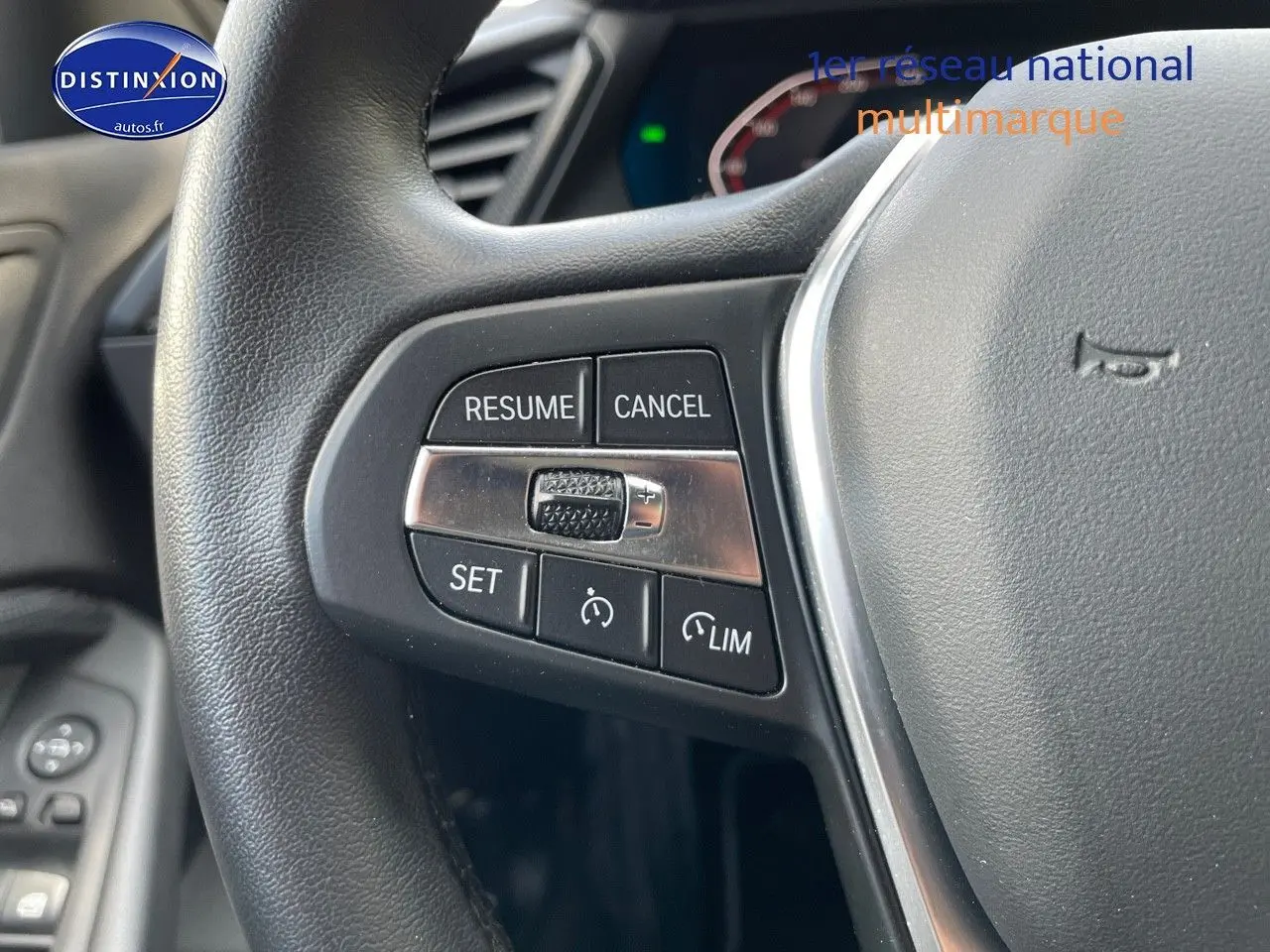 Gros plan sur les commandes au volant en cuir noir de la BMW Série 1 gris minéral, version Edition Sport 2021.