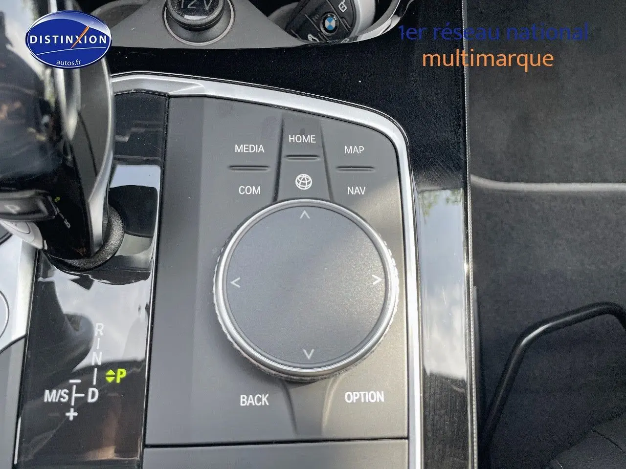 Gros plan sur la molette de commande multimédia et levier de vitesse d'une BMW Série 1 gris minéral 2021.