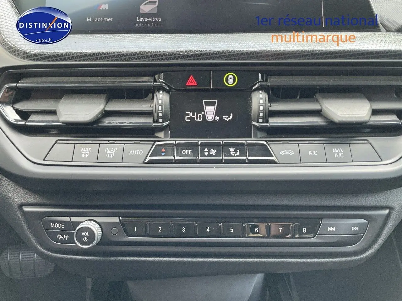 Vue rapprochée du tableau de bord de la BMW Série 1 gris minéral, montrant la console centrale et les commandes climatiques.