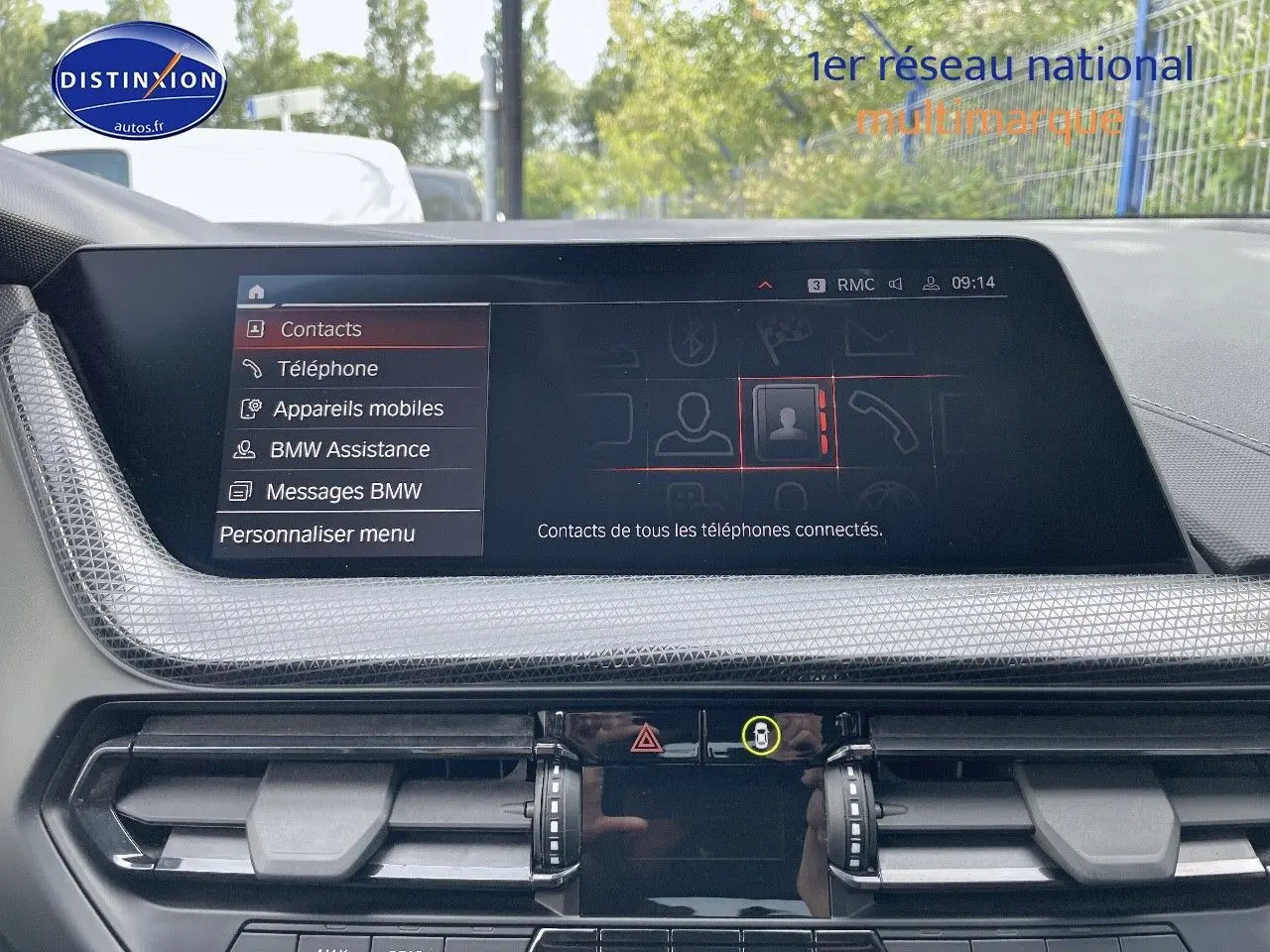 Vue rapprochée de l’écran central et des commandes de la planche de bord d’une BMW Série 1 gris minéral métal de 2021.