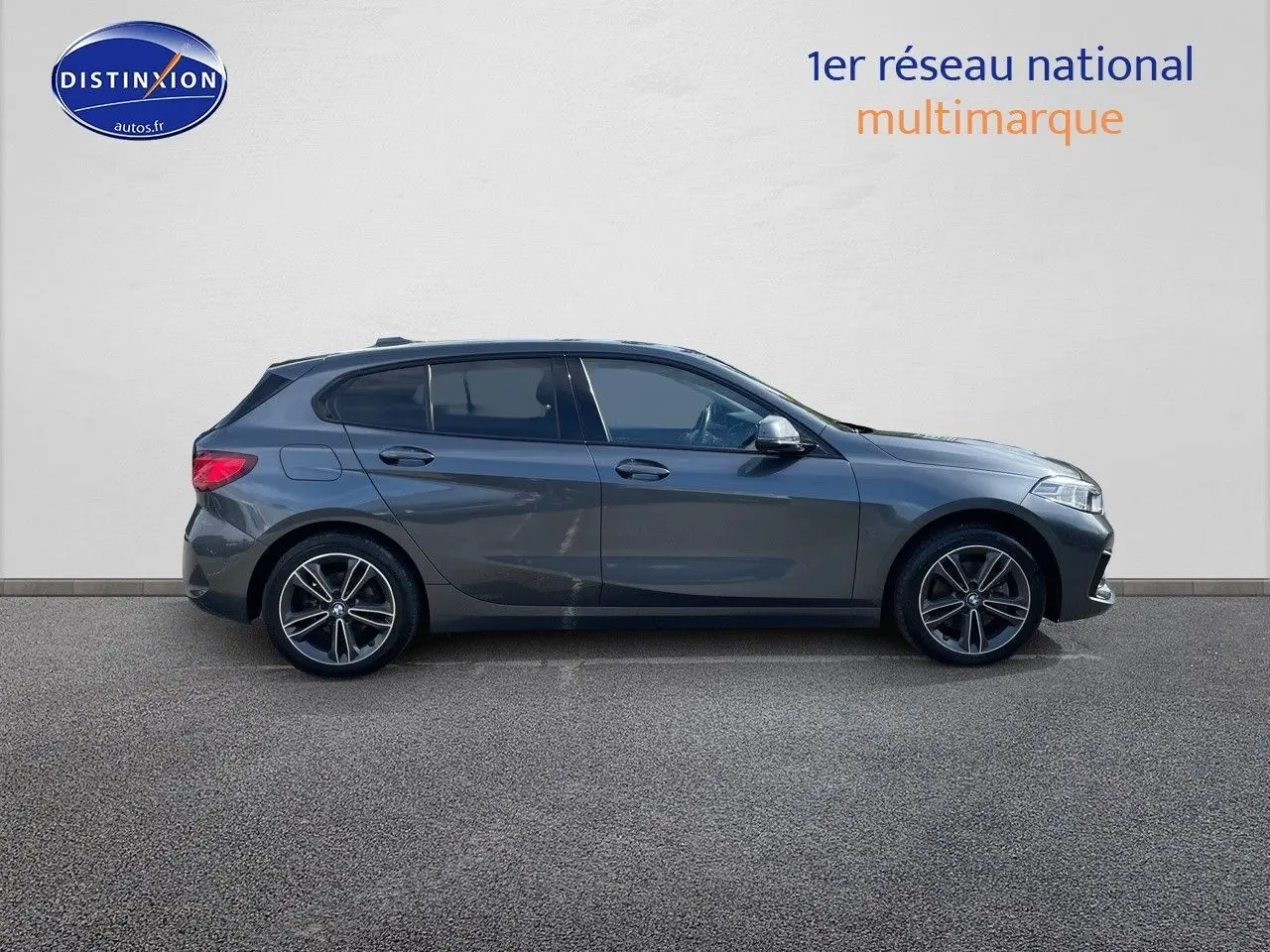 Profil droit d'une BMW Série 1 118i gris minéral métallisé avec jantes alliage bicolores, vue extérieure.