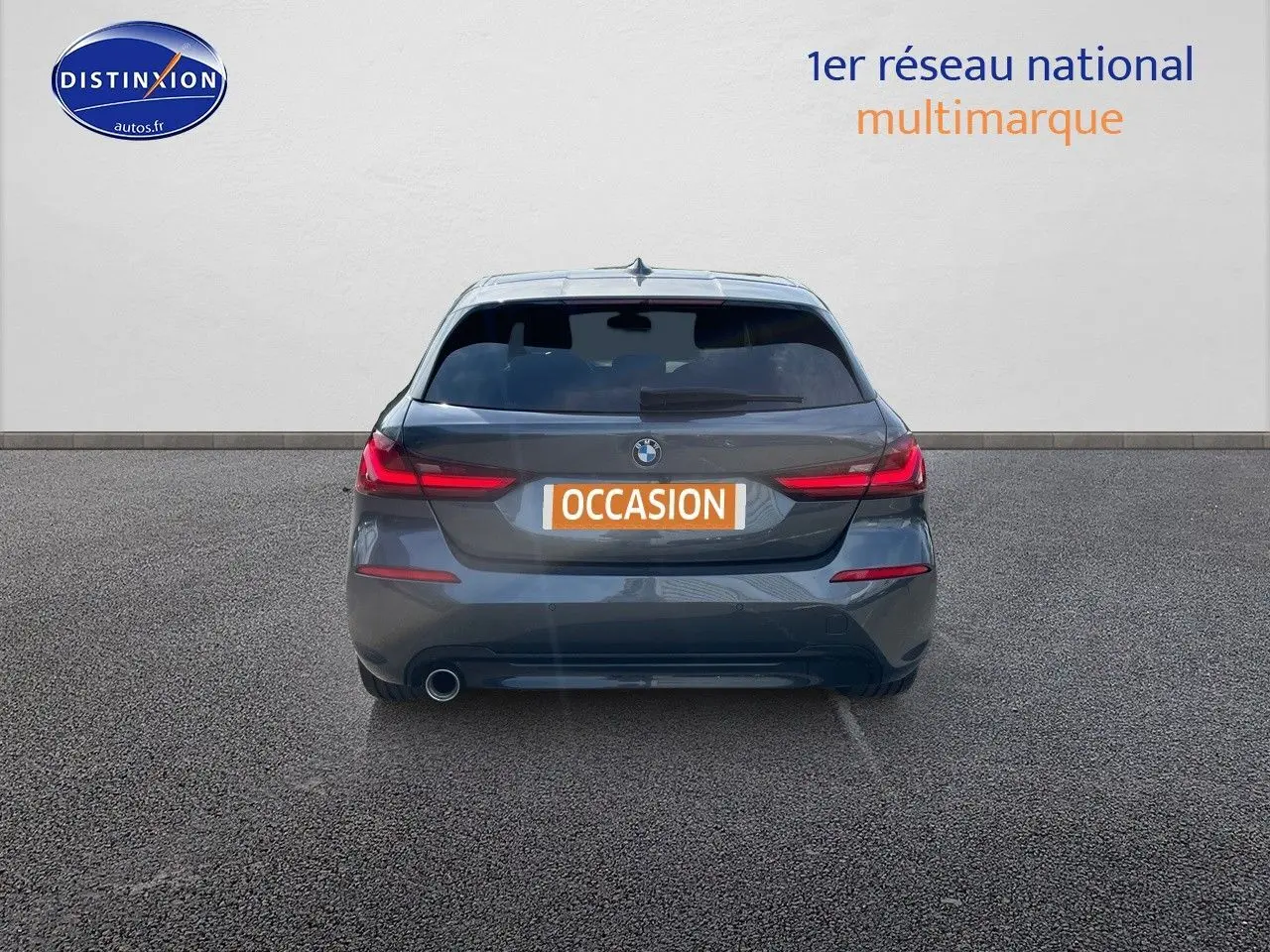 Vue arrière d'une BMW Série 1 gris minéral métallisé avec feux LED et plaque d'immatriculation "OCCASION" visible.