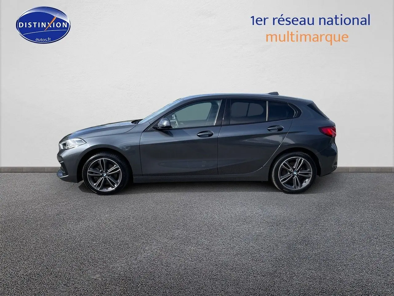 BMW Série 1 118i gris minéral métal vue de profil côté gauche, avec jantes alliage bicolores et 5 portes visibles.