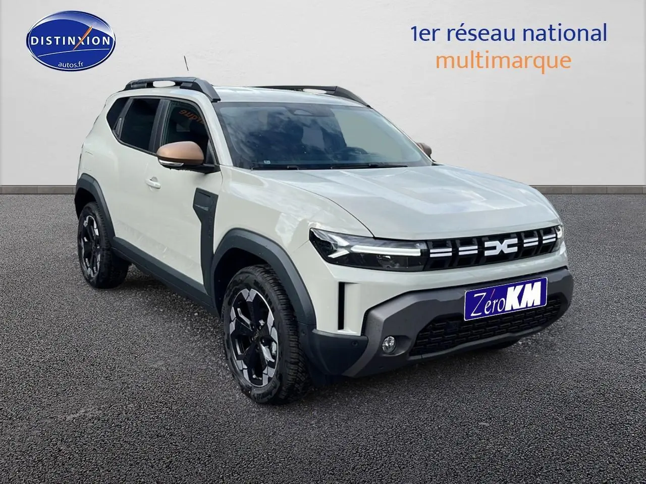 Vue 3/4 avant d'un Dacia Duster 2025 couleur Sandstone avec barres de toit et jantes noires distinctives.