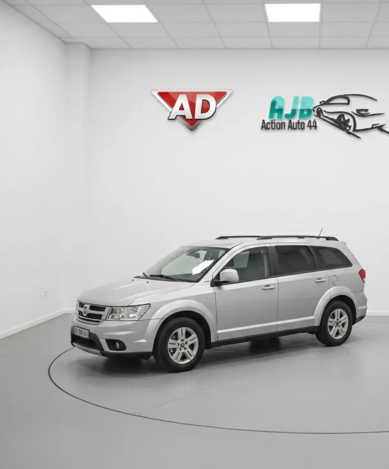 Vue arrière du coffre ouvert d'un FIAT Freemont gris, montrant la troisième rangée de sièges en position verticale.