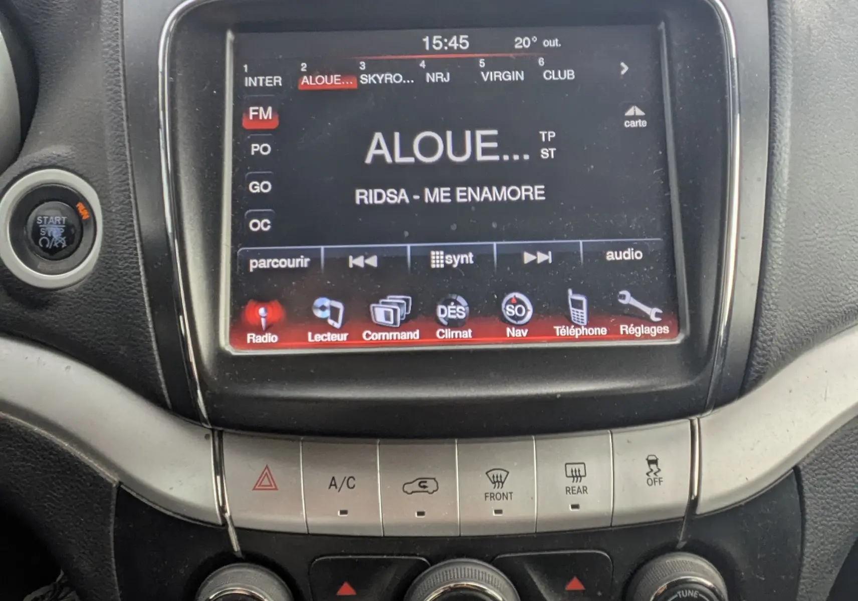Vue arrière d'un FIAT Freemont gris avec barres de toit et lunette arrière surteintée dans un espace blanc.