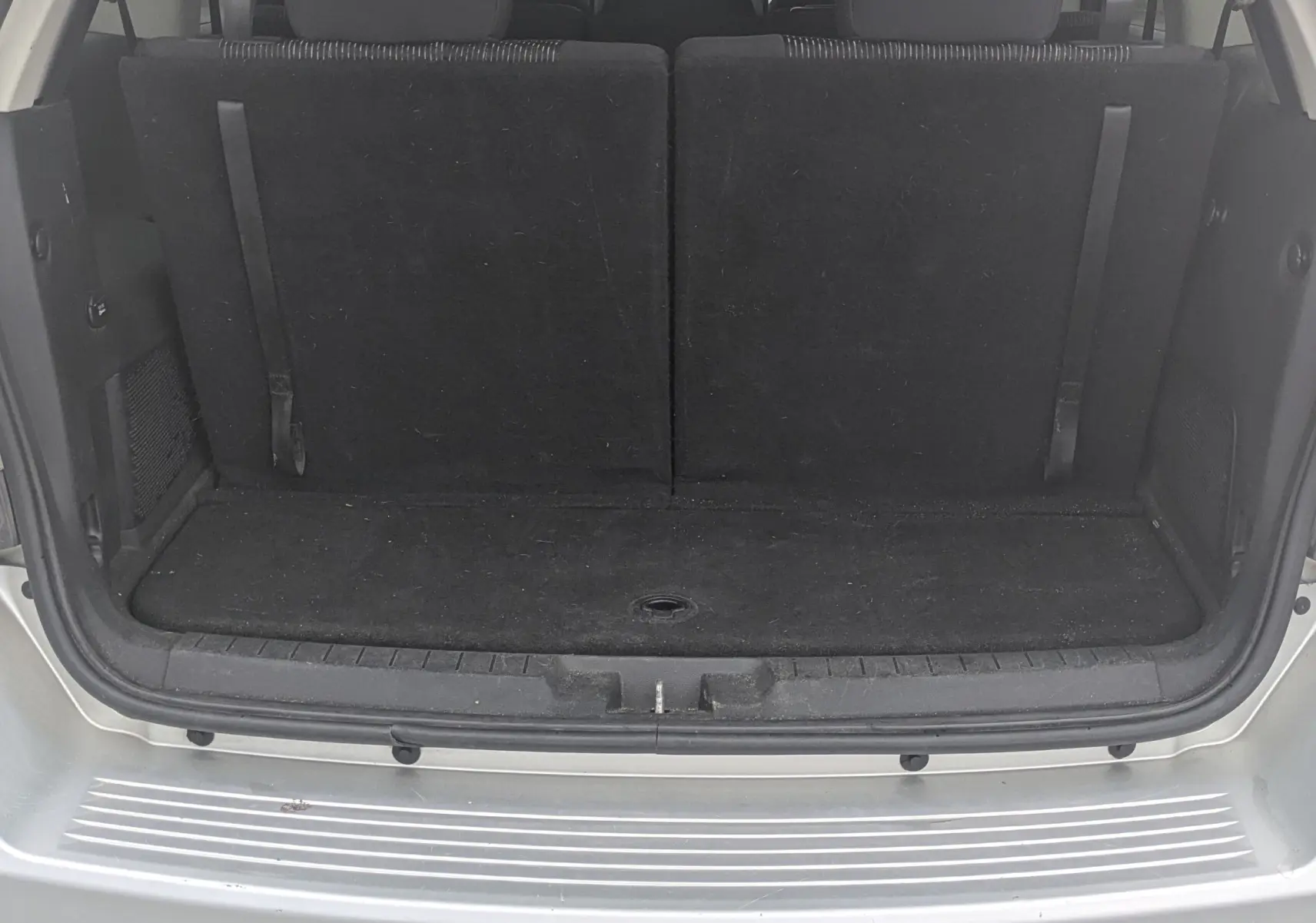 Vue avant d'un FIAT Freemont gris 2012 avec calandre chromée et phares halogènes, sur fond neutre intérieur.