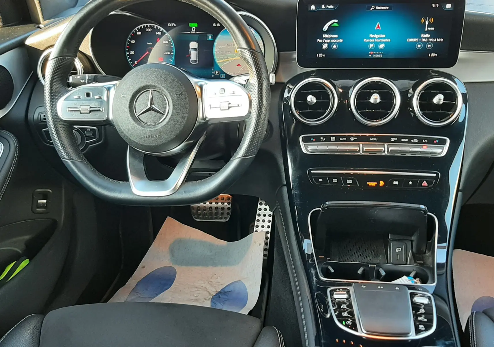 Vue intérieure avant du tableau de bord et volant noir d'une Mercedes GLC Coupé 300 4MATIC AMG Line 2019 avec écran tactile et commandes intégrées.