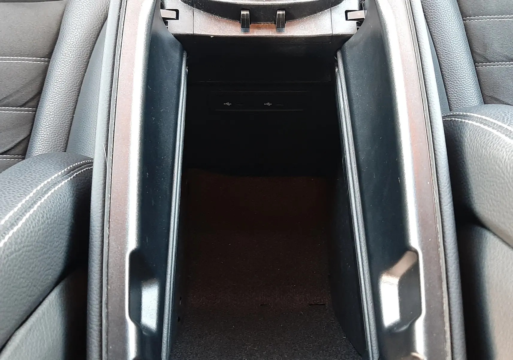 Vue rapprochée de la console centrale ouverte en cuir noir du Mercedes GLC Coupé 300 AMG Line 2019.