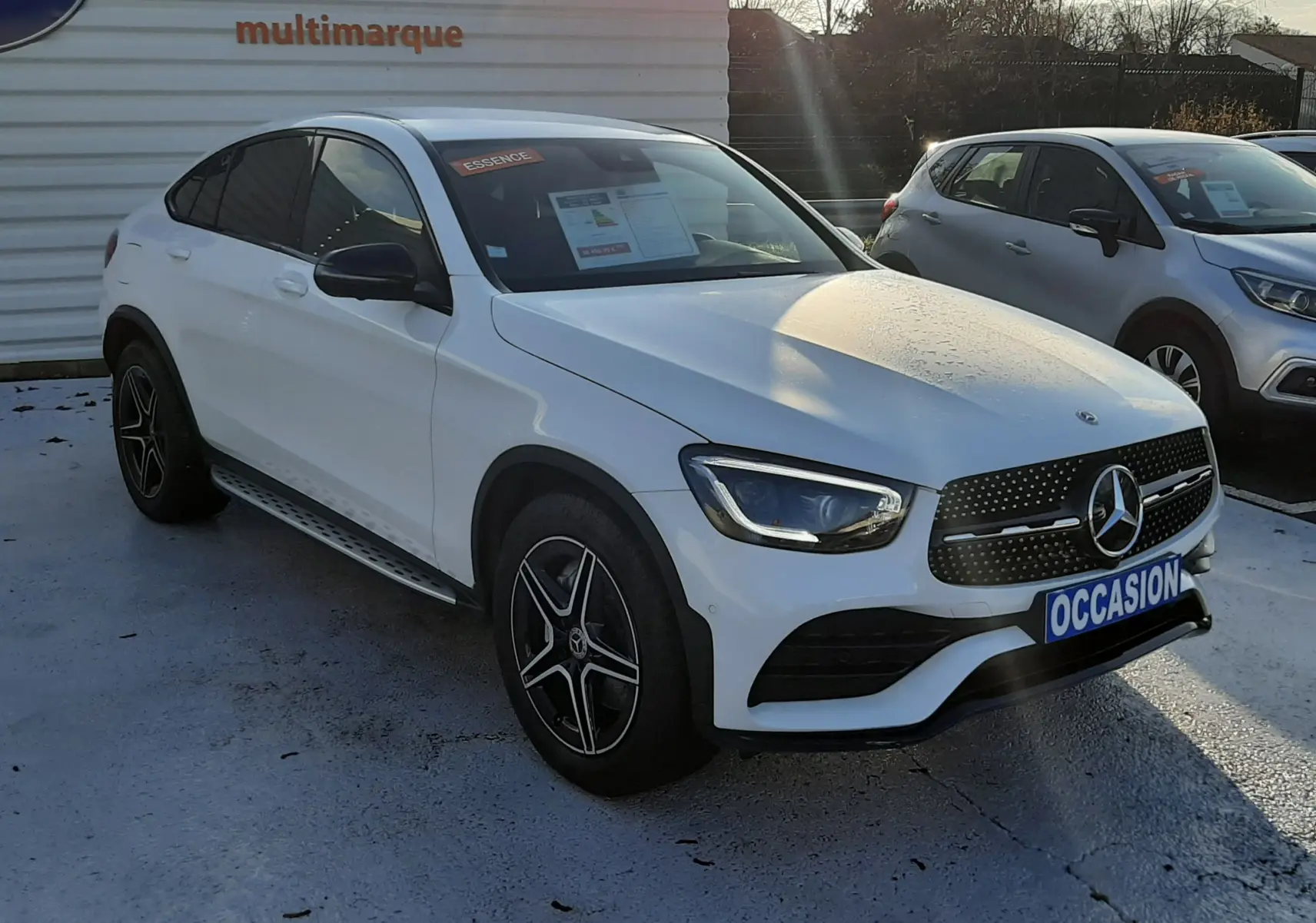 Mercedes GLC Coupé blanc vu en 3/4 avant droit, avec jantes AMG noires et calandre étoilée distinctive.