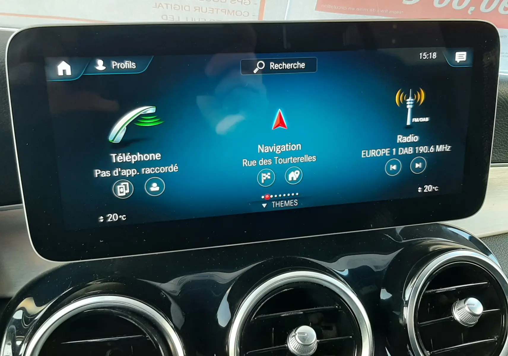 Écran tactile central du tableau de bord d'une Mercedes GLC Coupé blanc, affichant navigation et radio.