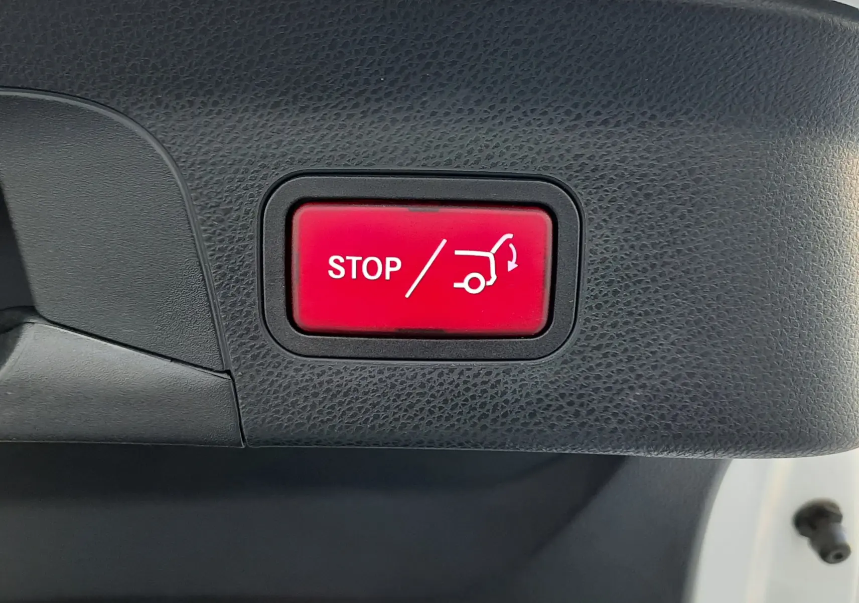 Bouton rouge "STOP" pour fermeture automatique du hayon, intérieur noir du coffre d'un Mercedes GLC Coupé blanc 2019.