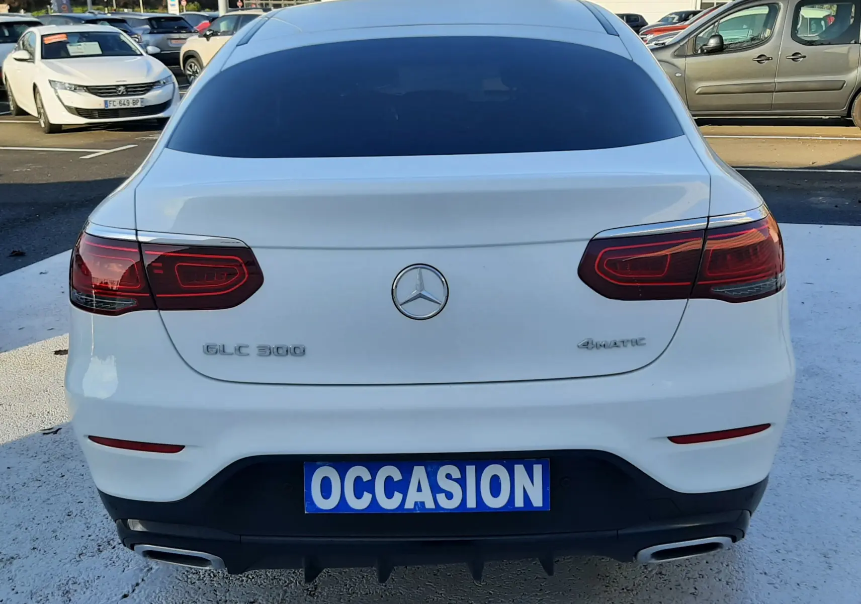Vue arrière d'un Mercedes GLC 300 4MATIC Coupé blanc avec feux LED et double sortie d'échappement chromée.