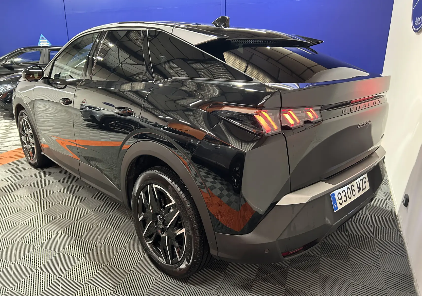 Vue 3/4 arrière droite du Peugeot 3008 noir hybride 2025 avec feux LED et jantes alliage noires.