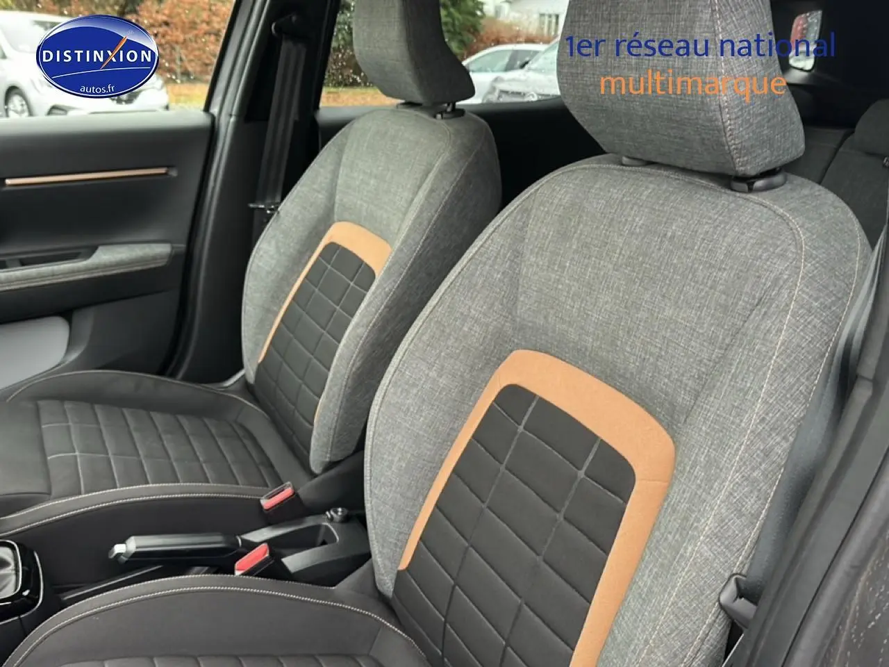 Vue intérieure côté avant droit montrant les sièges tissu gris avec inserts noirs et orange du Citroën C3 Aircross 2025.