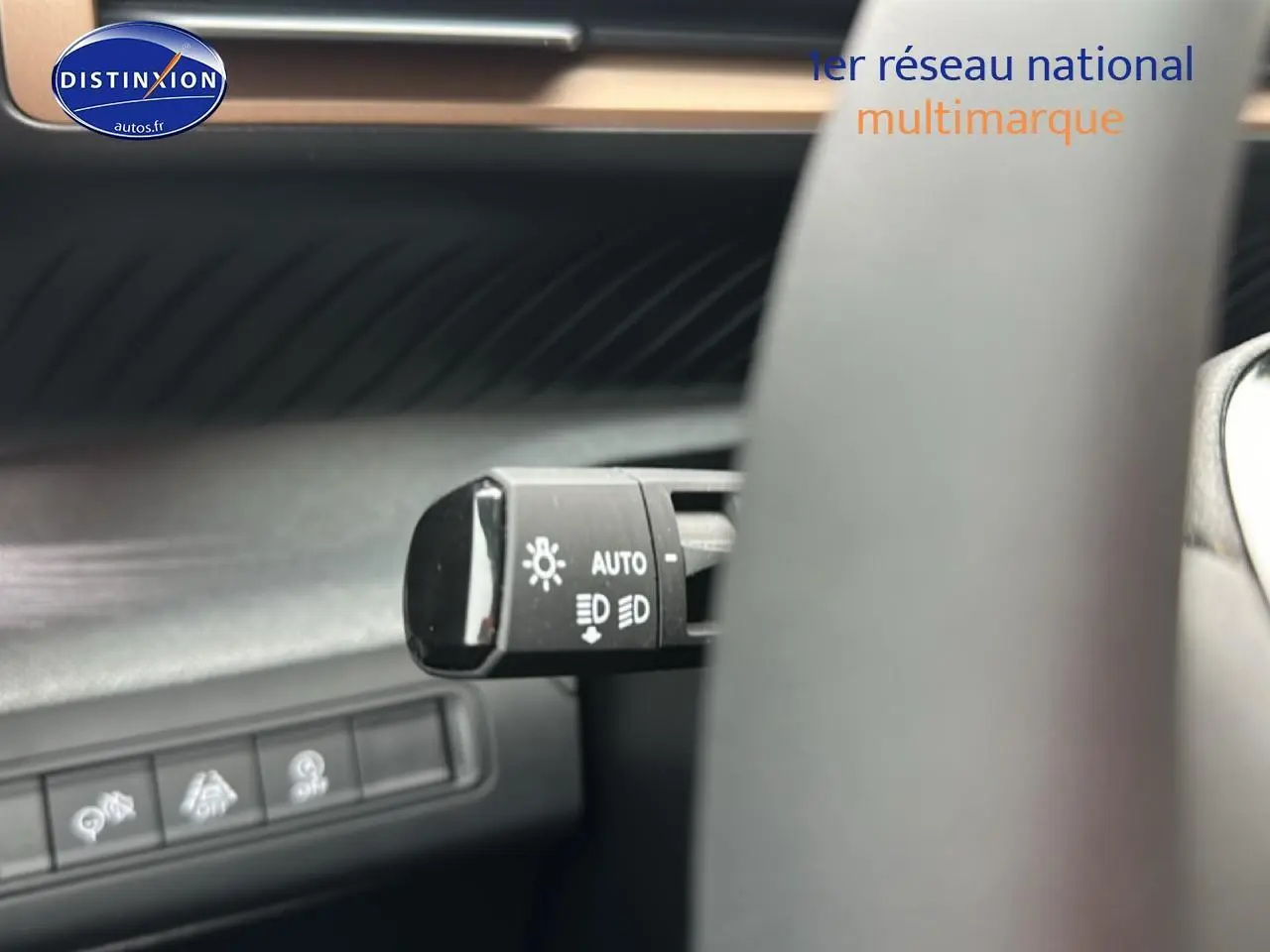 Gros plan sur la commande des phares automatiques à gauche du volant dans l’habitacle gris du Citroën C3 Aircross 2025.