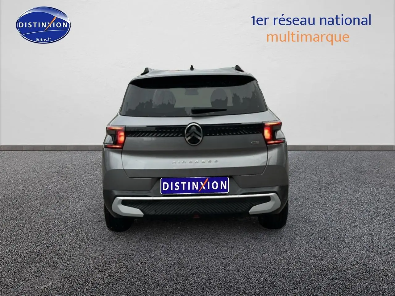 Vue arrière d'un Citroën C3 Aircross gris 2025 avec feux arrière allumés et lunette arrière teintée.