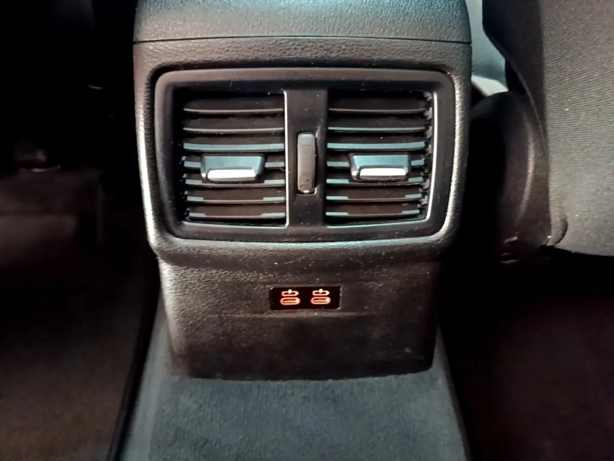 Détail des aérateurs arrière et ports USB illuminés dans l’habitacle noir du BMW X1 sDrive20i 2020.