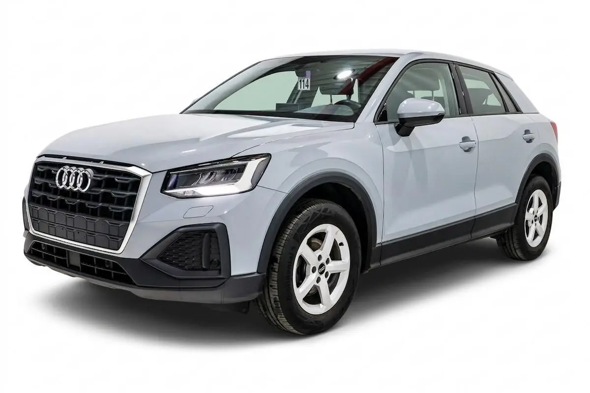 Audi Q2 gris en vue 3/4 avant droit, mettant en valeur sa calandre noire et ses jantes blanches cinq branches.