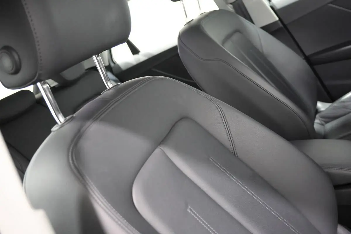 Gros plan sur les sièges avant en cuir noir de l'Audi Q2 TFSI 110, vue intérieure côté conducteur.