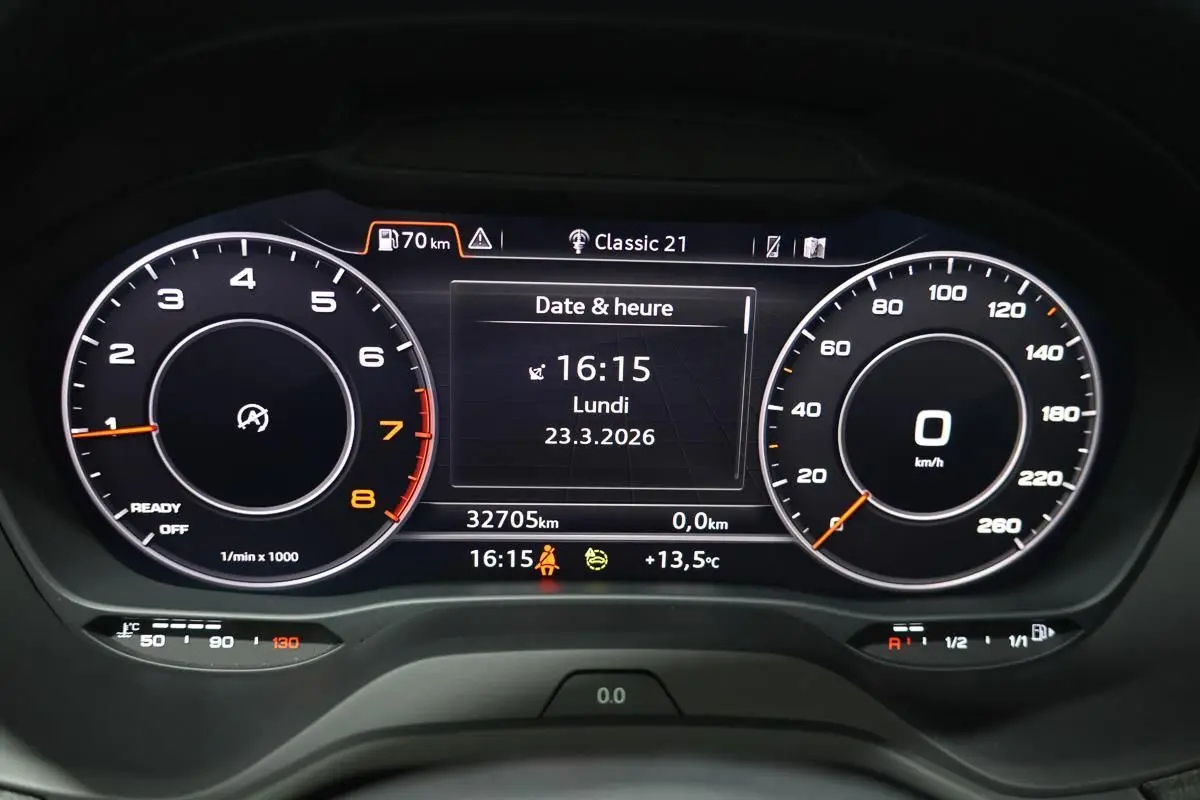 Tableau de bord numérique de l'Audi Q2 TFSI 110, affichage date et heure, compte-tours et vitesse à 0 km/h.