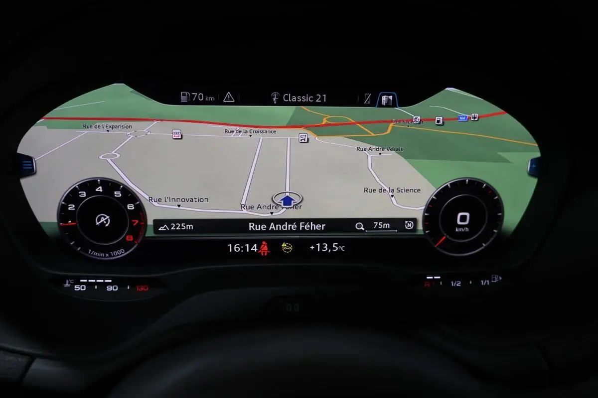 Affichage du virtual cockpit Audi Q2 TFSI 110 gris, montrant la navigation GPS avec carte et informations de conduite.