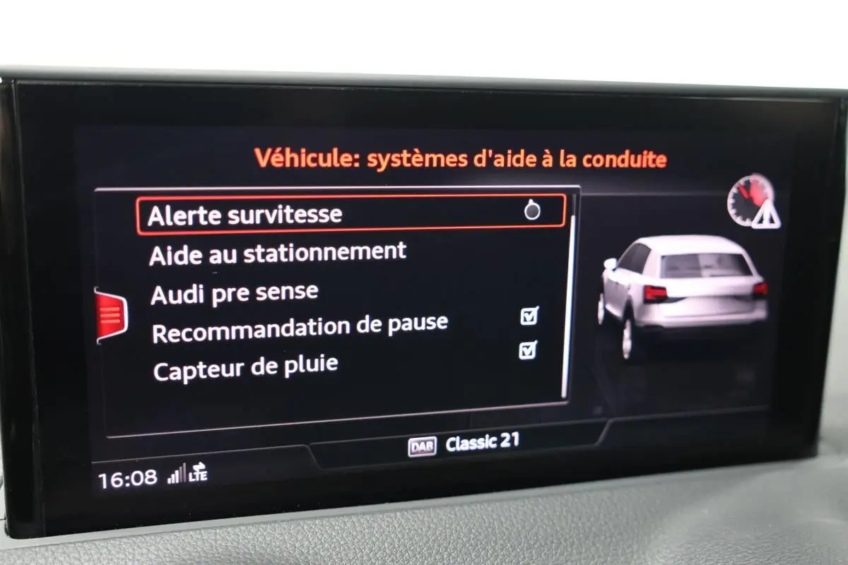 Écran du système d'aide à la conduite Audi Q2 TFSI 110 gris, affichant les options d'alerte et assistance au stationnement.