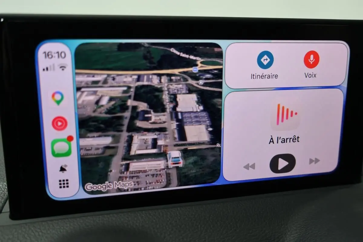 Écran central de l’Audi Q2 TFSI 110 gris 2023 affichant la navigation GPS en vue satellite et commandes vocales.