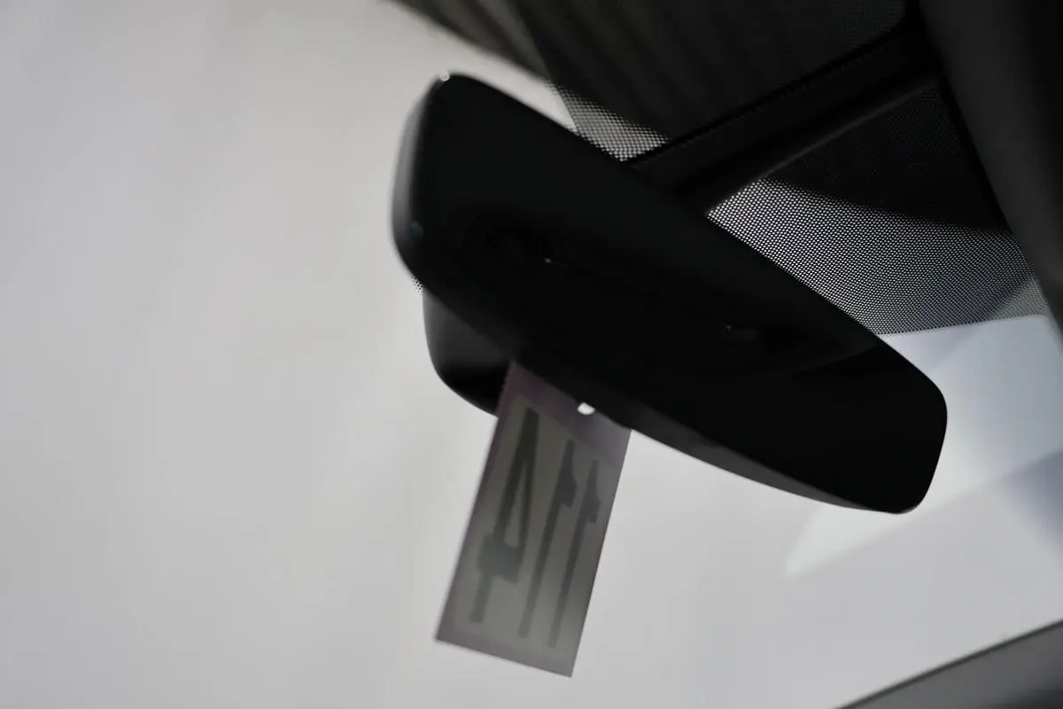 Vue intérieure centrée sur le rétroviseur intérieur d'un Audi Q2 gris 2023 avec pare-brise clair.