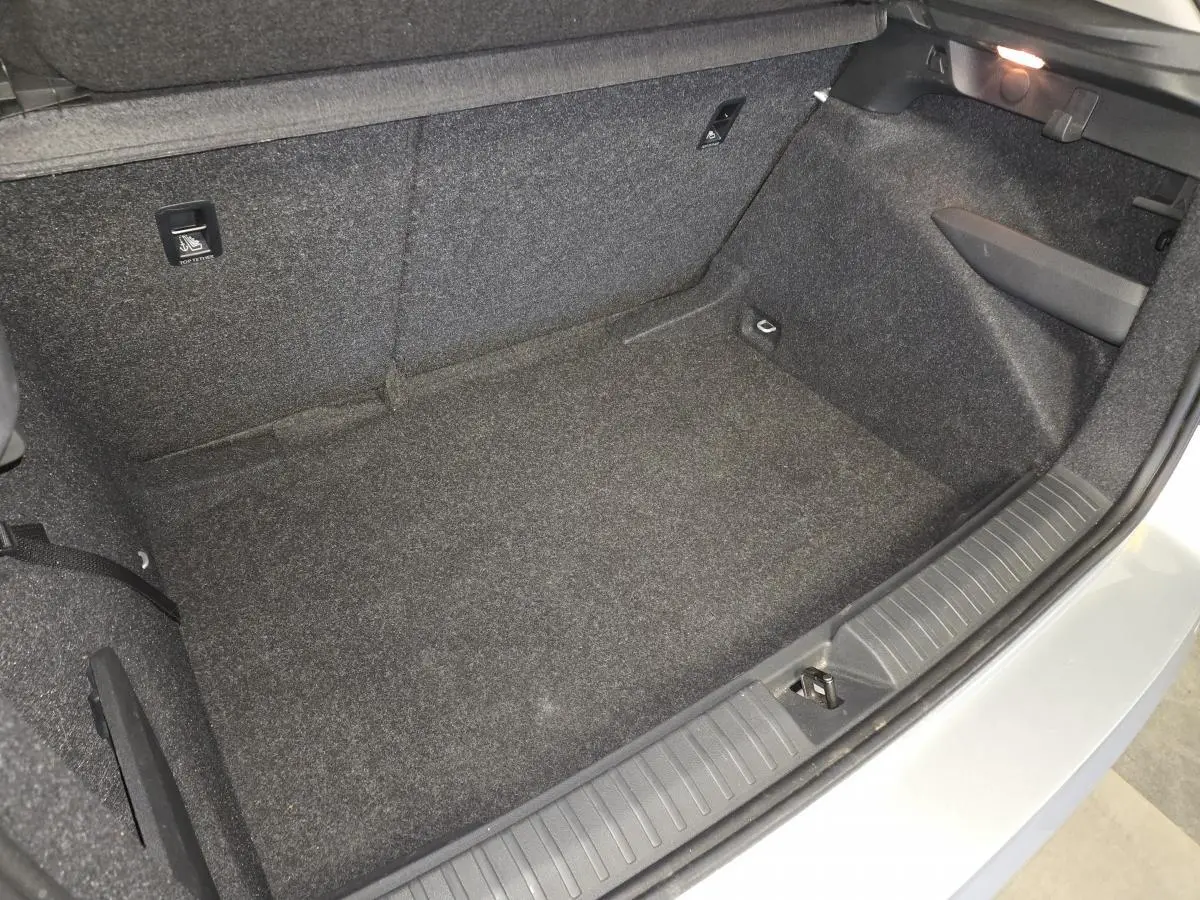Coffre ouvert vu de dessus du Skoda Kamiq gris 2023, montrant l'espace de chargement vide et les finitions intérieures.