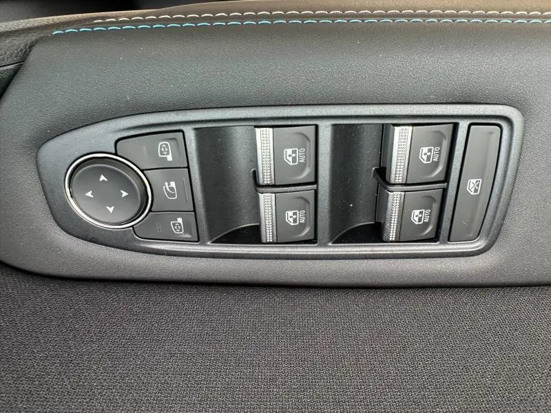 Vue rapprochée des commandes de lève-vitres et rétroviseurs sur la porte côté conducteur du Renault Captur Gris Rafale/Noir Étoilé 2026.