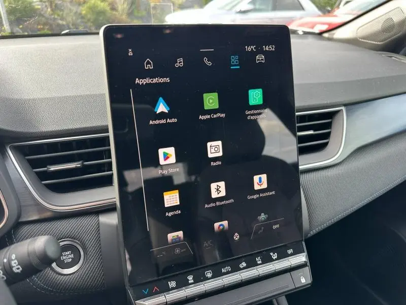 Vue intérieure centrée sur l'écran tactile du tableau de bord du Renault Captur 1.8 E-Tech hybride, avec détails des commandes et finition noire.