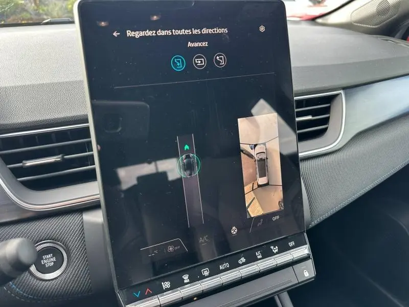 Écran tactile central du Renault Captur 2026 montrant l'aide au stationnement avec vue 360°, intérieur gris et noir.