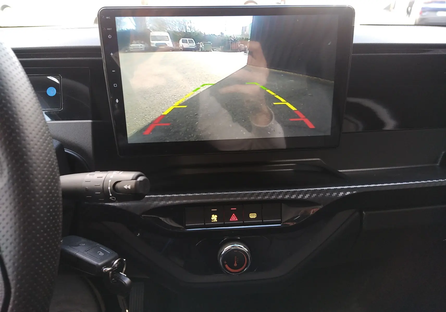 Vue intérieure centrée sur l'écran de caméra de recul du tableau de bord d'une Ligier Myli REVO D+ MAX gris graphite 2026.