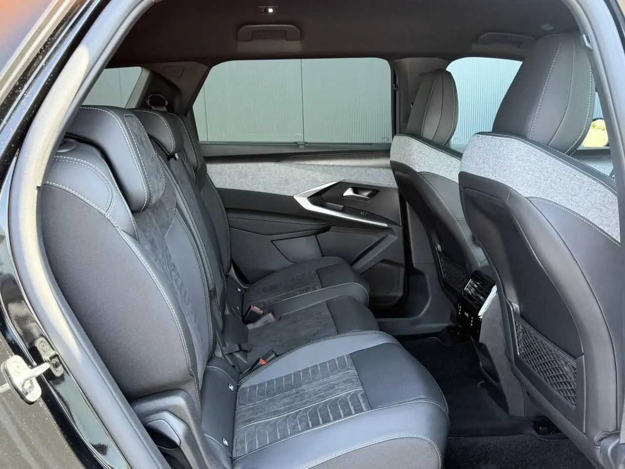 Vue intérieure côté gauche sur la banquette arrière en sellerie Alcantara gris et tissu chiné du Peugeot 5008 noir Perla.