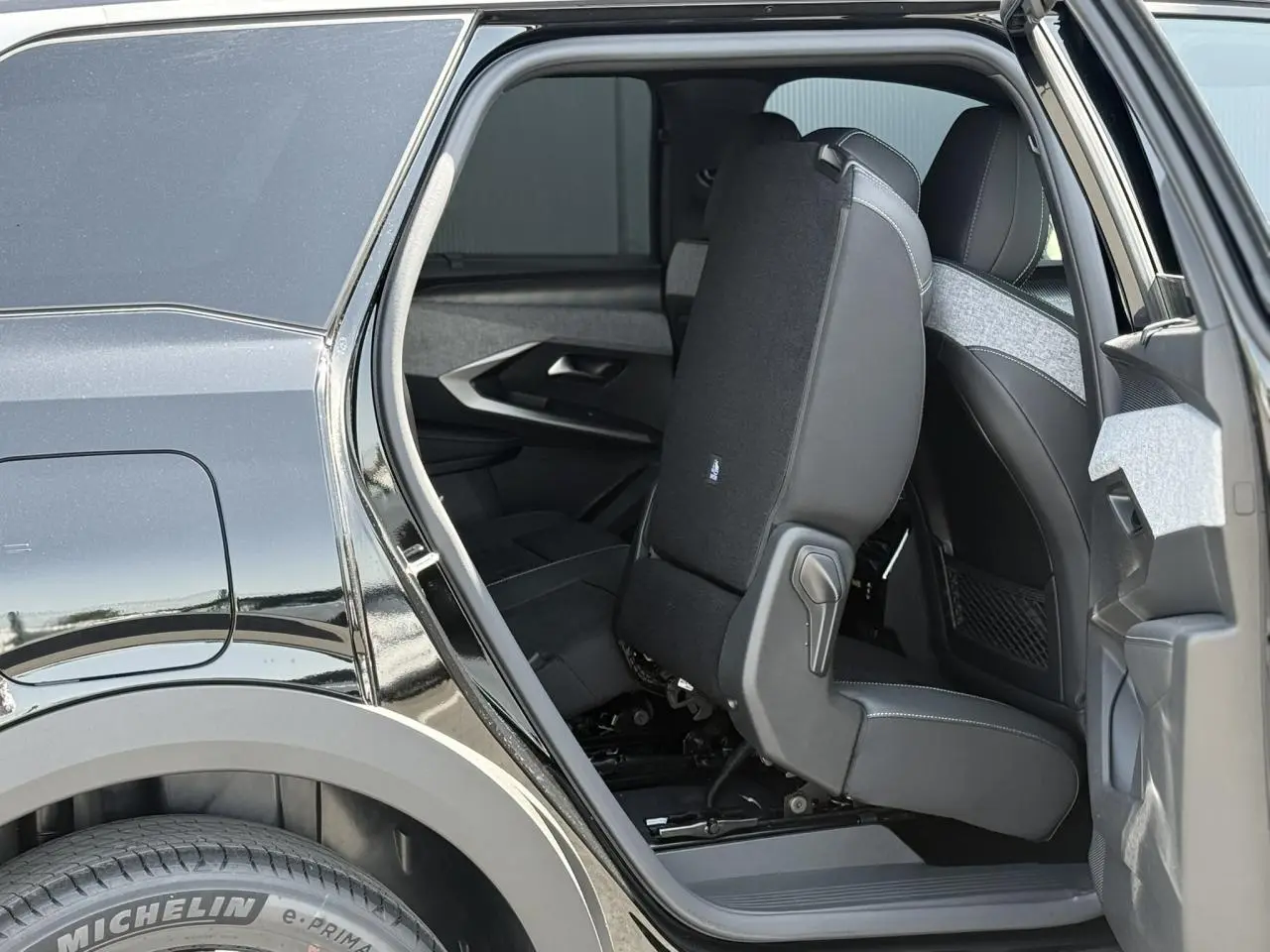 Vue côté gauche arrière du Peugeot 5008 noir Perla, siège rabattable en Alcantara avec surpiqûres visibles.