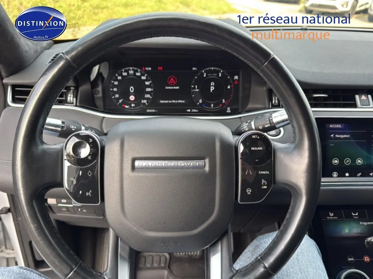 Vue rapprochée du volant cuir noir du Range Rover Evoque 2019 avec tableau de bord numérique et écran tactile visible.
