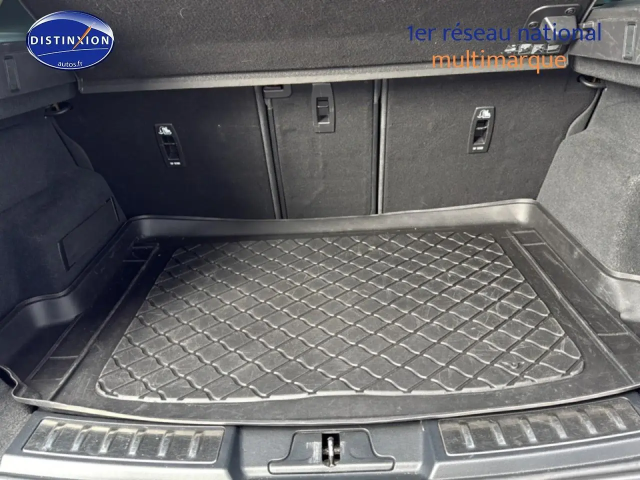Coffre spacieux du Range Rover Evoque 2019 avec tapis de protection noir et banquette arrière rabattable.