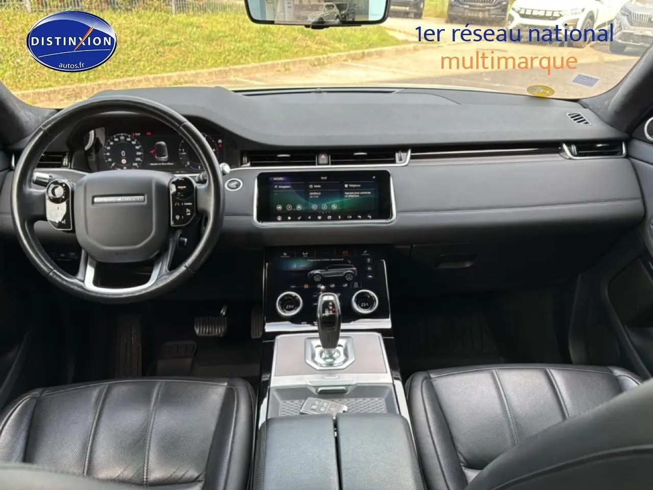 Intérieur noir du Range Rover Evoque 2019, vue frontale sur tableau de bord, volant cuir et console centrale tactile.
