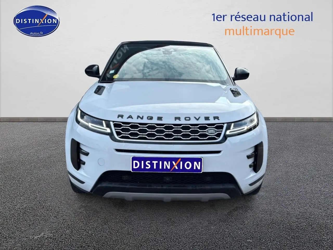 Vue avant d'un Range Rover Evoque blanc avec toit noir, calandre hexagonale et phares LED allumés.