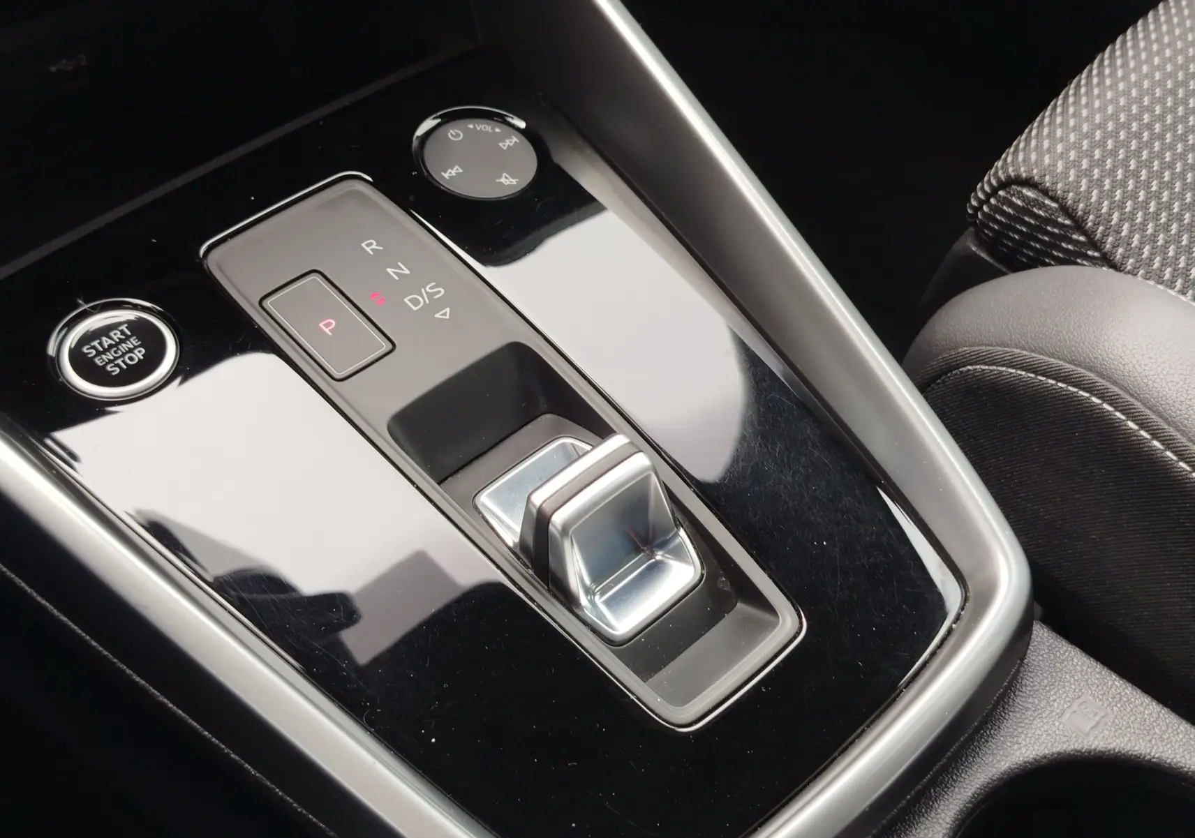 Gros plan sur la console centrale noire brillante de l’Audi A3 Sportback 30 TFSI avec sélecteur de boîte auto et bouton start/stop.