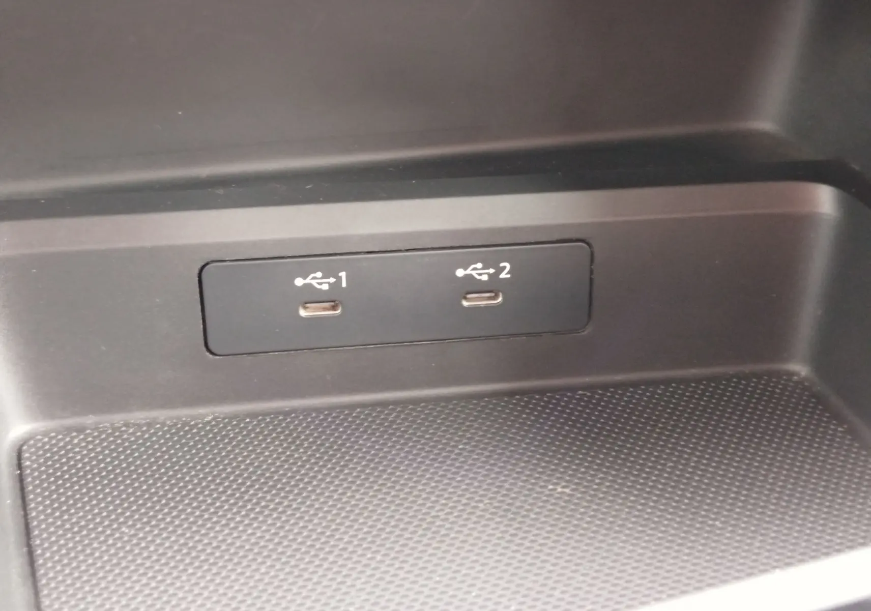 Gros plan sur les deux ports USB-C intégrés dans la console intérieure noire de l'Audi A3 Sportback blanc Glacier.