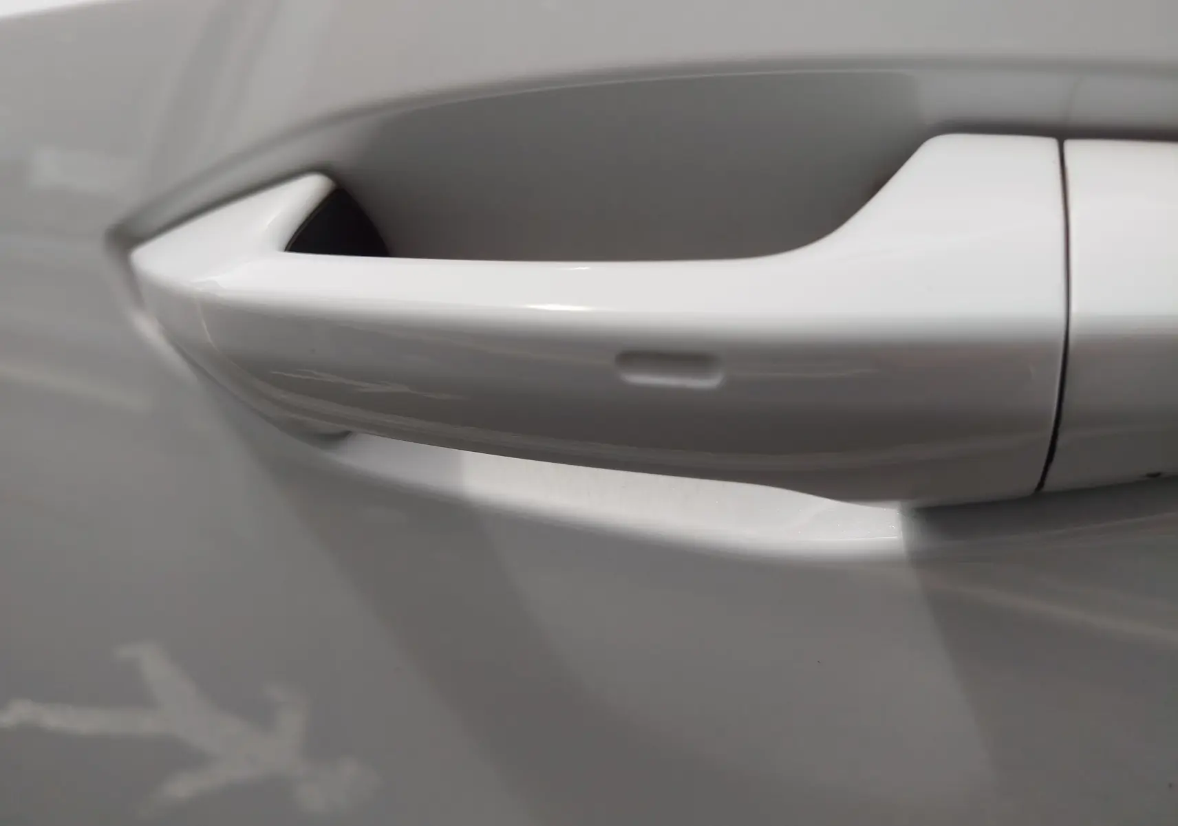 Poignée de porte blanche Glacier métallisé en gros plan sur une Audi A3 Sportback 30 TFSI hybride léger.