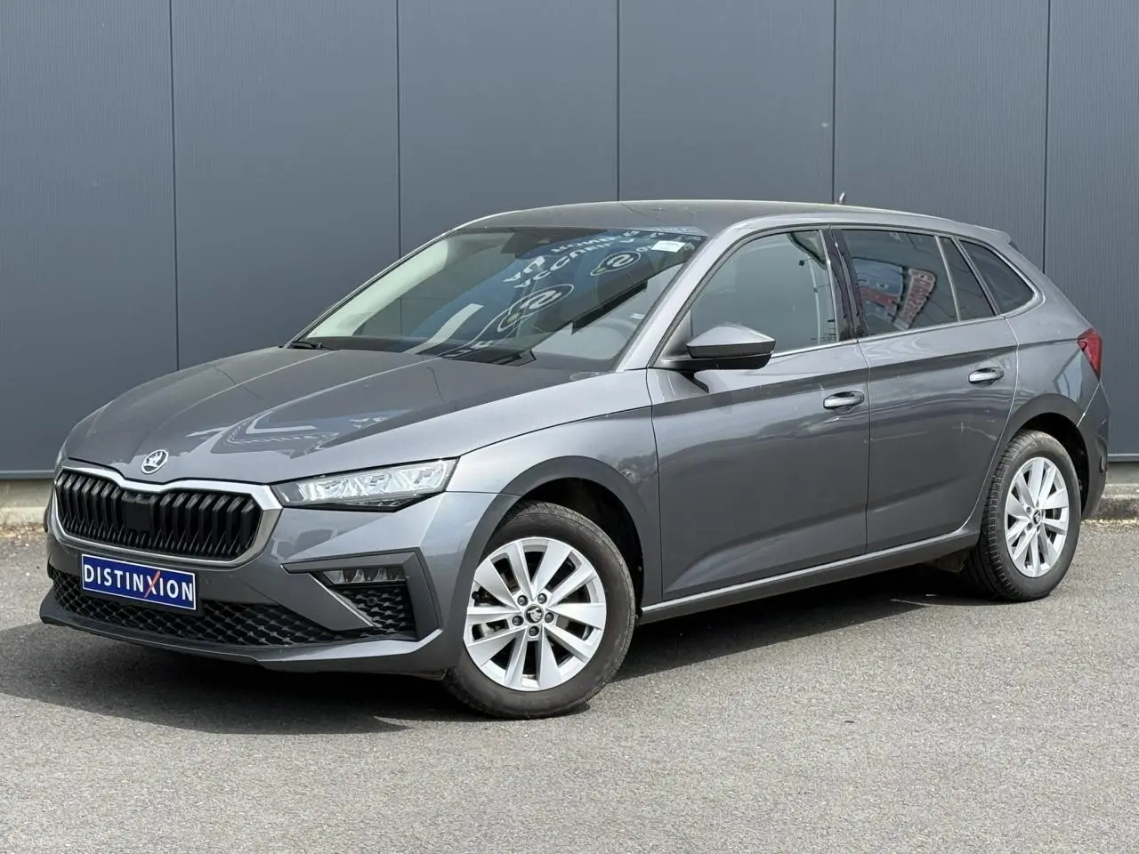 Vue 3/4 avant droit d'une Skoda Scala gris graphite avec jantes alliage 16 pouces et calandre noire distinctive.