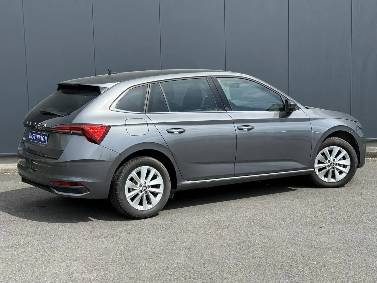 Vue latérale droite d'une Skoda Scala TSI 116 gris graphite avec vitres arrière surteintées et jantes alliage 16 pouces.