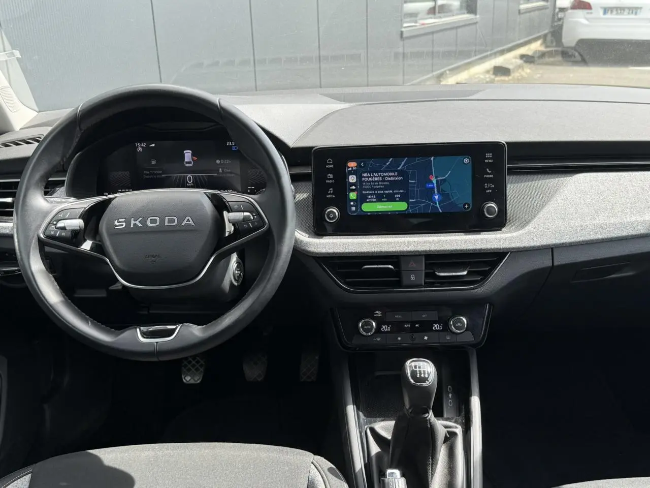 Vue intérieure frontale du tableau de bord de la Skoda Scala TSI 116, volant cuir et écran tactile 8,25 pouces.