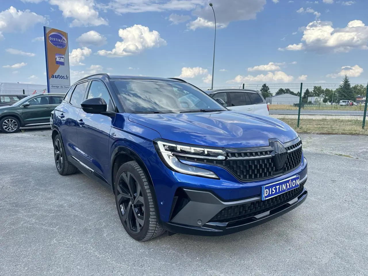 Renault Austral 2024 bleu avec toit noir, vue 3/4 avant mettant en valeur la calandre et les phares LED distinctifs.