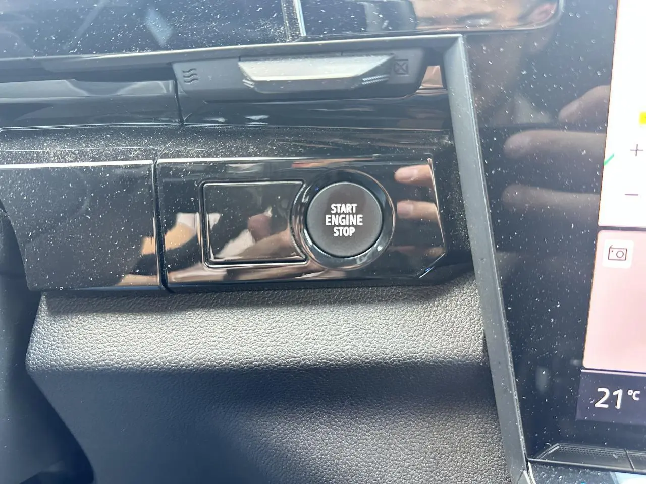 Gros plan sur le bouton Start Engine Stop du tableau de bord noir brillant du Renault Austral 2024 hybride.